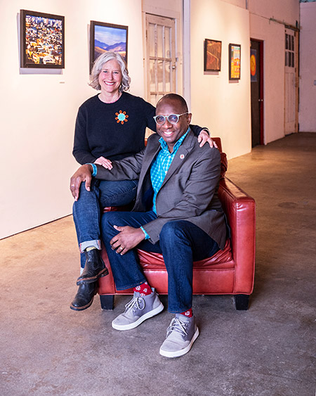 Herb and Angie Caldwell sitting together on a red leather chair